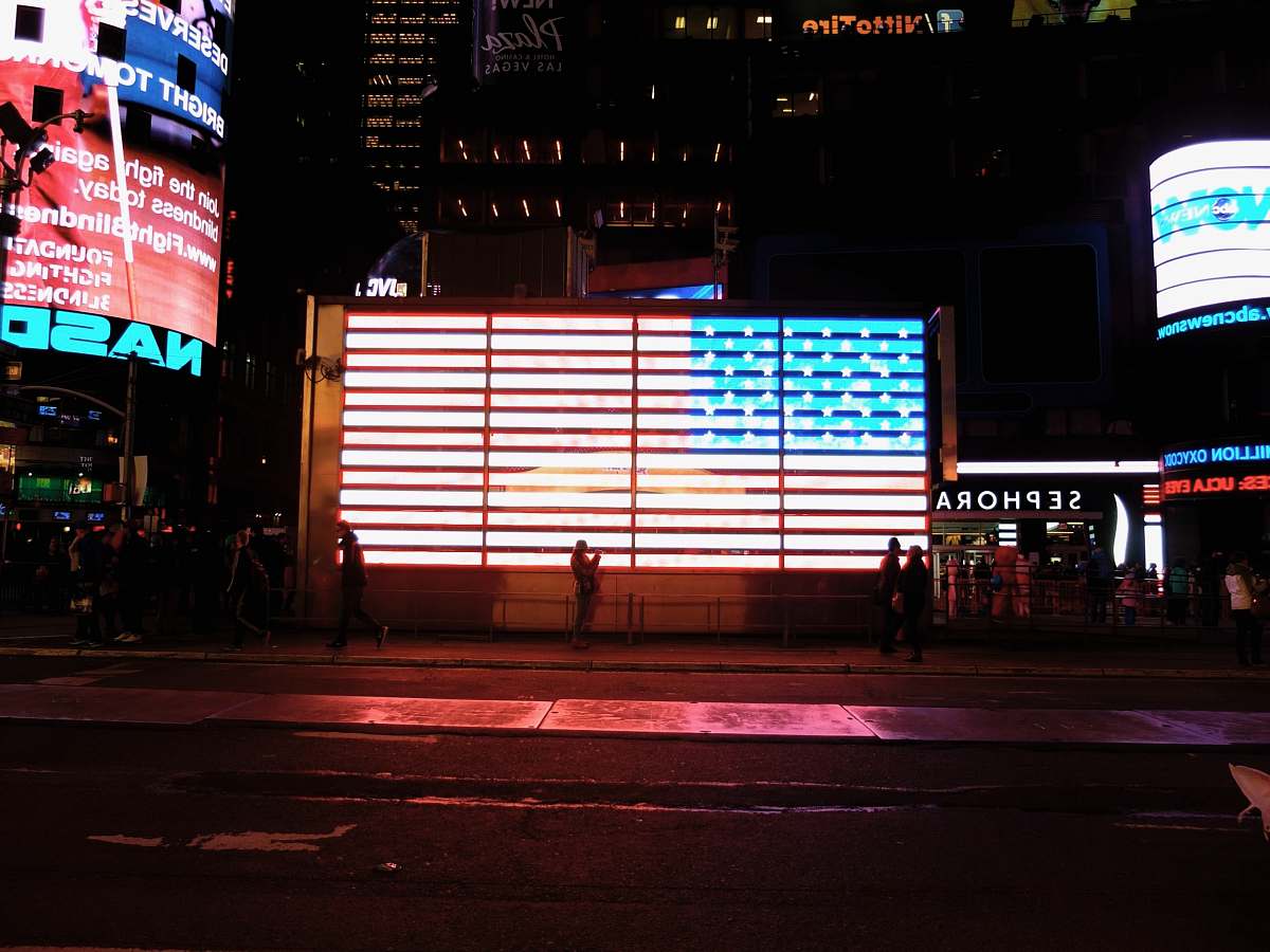 billboard people walking on sidewalk beside building new york